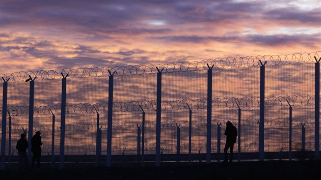 Uprchlíci postávají u plotu, který vyrostl u dálnice ve francouzském Calais (3....
