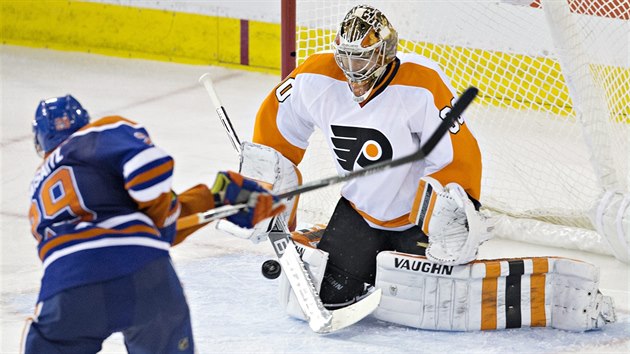 Brank Philadelphie Michal Neuvirth zasahuje proti stele Leona Draisaitla z Edmontonu.