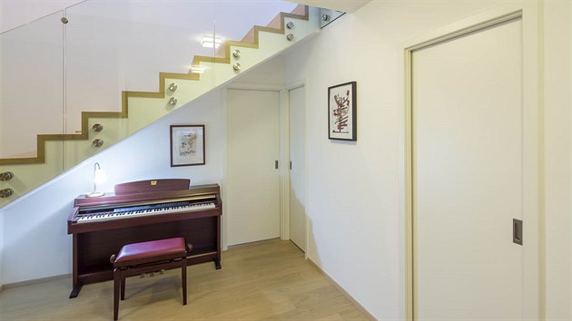 V prostoru pod schoditm se nael prostor pro pianino, u kterho rda relaxuje majitelka domu.