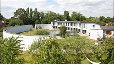 Bílá stavba od britského architektonického studia Norman a Dawbarn Architects...