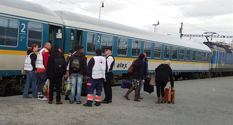 Uprchlíci s pracovníky eského erveného kíe na nádraí v Plzni. (18....