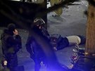 Policisté nedaleko koncertní sín Bataclanu v Paíi stojí u jedné z obtí...