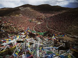 Tibetan prayer flags flutter above the Larung valley and its Larung Wuming...