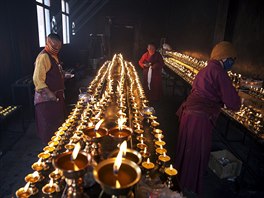 Tibetan Buddhist nuns keep yak butter lamps burning at a Buddhist laymen lodge...