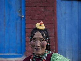 Ethnic Tibetan woman from Kham area wears traditional amber and other stone...