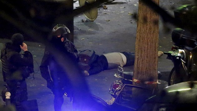 Policist nedaleko koncertn sn Bataclanu v Pai stoj u jedn z obt teroristickho toku. (14. listopadu 2015)