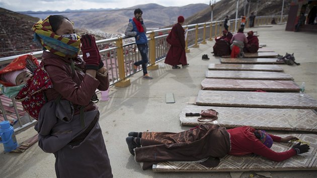 Ethnic Tibetan woman, carrying her baby on the back, prays at a monastery above the Larung Wuming Buddhist Institute, located some 3700 to 4000 metres above the sea level in remote Sertar county, Garze Tibetan Autonomous Prefecture, Sichuan province
