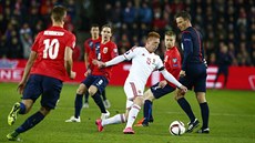Ma�arský zálo�ník Laszlo Kleinheisler p�i gólové akci kli�kuje mezi norskými...