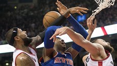 Carmelo Anthony (uprost�ed) z New Yorku bojuje o mí� s Jamesem Johnsonem...