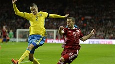 védský fotbalista Mikael Lustig (vlevo) v souboji  s Rizou Durmisim z Dánska.