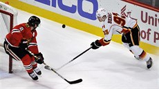 Sam Bennett (93) z Calgary a Duncan Keith (2) z Chicaga bojují o puk.