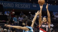 C. J. McCollum (vpravo) z Portlandu stílí na ko Charlotte pes Jeremyho Lamba.