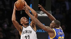 Draymond Green (vpravo) z Golden State brání  Markela Browna z Brooklynu.