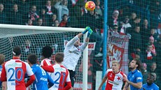 Slávistický gólman Martin Berkovec (v bílém) vyboxoval balón do bezpe�í v duelu...