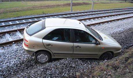 Pátení nehoda u Bystiky - auto ve smyku vylétlo ze silnice na koleje.