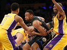 Jabari Parker (v tmavém) z Milwaukee proniká mezi obránci LA Lakers. Vlevo...
