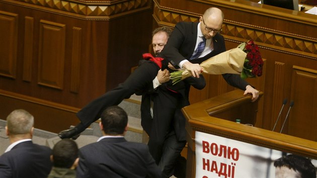 Ukrajinský zákonodárce Oleh Barna se pokusil v kyjevském parlamentu odtáhnout premiéra Arsenije Jaceňuka od řečnického pultu (11. prosince 2015)