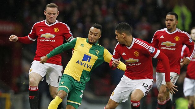 Nathan Redmond z Norwiche se prodr dvojblokem Wayne Rooney (vlevo) - Chris Smalling. Vemu z dlky pihl jet Memphis Depay.