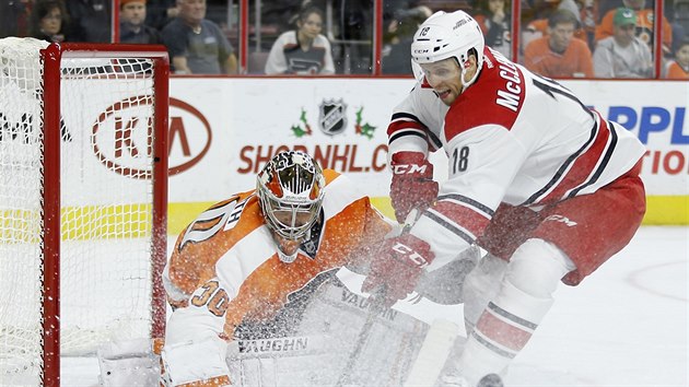 Michal Neuvirth hld branku Philadelphie ped pokusem Jaye McClementa z Caroliny.