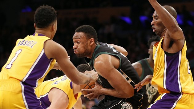 Jabari Parker (v tmavm) z Milwaukee pronik mezi obrnci LA Lakers. Vlevo mladk  D'Angelo Russell, vpravo vetern Kobe Bryant.