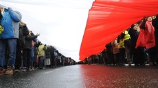 Backers of Poland's ruling conservative party carry a huge national flag as...