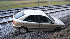 Páte�ní nehoda u Byst�i�ky - auto ve smyku vylétlo ze silnice na koleje.