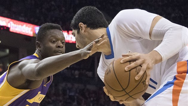 Julius Randle (vlevo) z LA Lakers pi obran Enese Kantera z Oklahoma City.