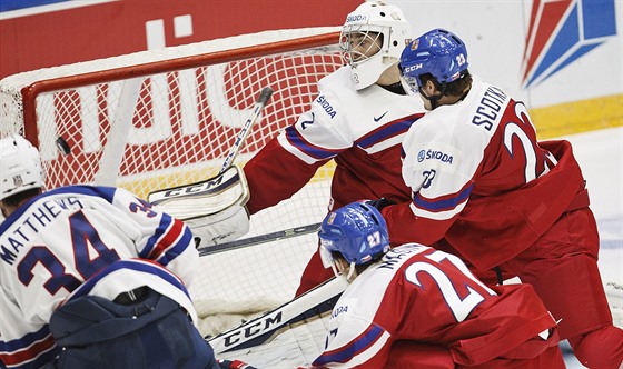 Americký hokejista Auston Matthews (zcela vlevo) překonává českého gólmana...