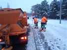 Pracovníci Praských slueb uklízejí sníh na autobusové zastávce Stranická.