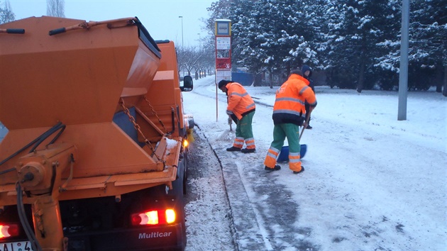 Pracovníci Praských slueb uklízejí sníh na autobusové zastávce Stranická.