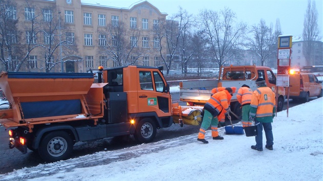 Pracovníci Praských slueb uklízejí sníh na autobusové zastávce Stranická.