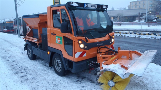 Pracovníci Praských slueb uklízejí sníh na autobusové zastávce Stranická.