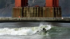 POD ZLATOU BRÁNOU. Surfa� brázdí rozbou�enou hladinu pod mostem Golden Gate v...