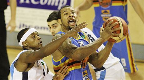 Jindichohradecký basketbalista Devareaux Manley (v modrém) útoí na kolínský...