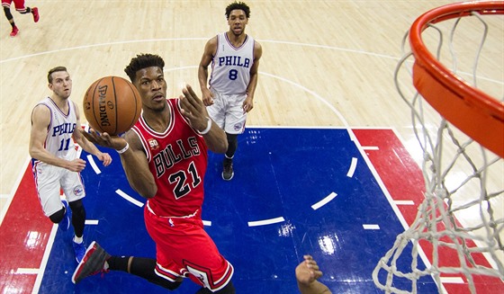 Jimmy Butler (v erveném) z Chicaga letí ke koi Philadelphie, sledují ho Nik...