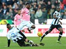 Obranou Udinese prochází Kwadwo Asamoah z Juventusu (v rovém), ve skluzu je...