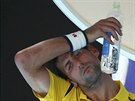 POT Z ELA! Srbský tenista Novak Djokovi si utírá pot bhem pauzy jeho zápasu...