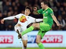 Ki Sung-Yueng (vlevo) v dresu Swansea bojuje o mí s kapitánem Sunderlandu...