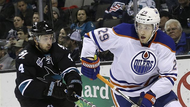 Leon Draisaitl (vpravo) z Edmontonu ujd Brendenu Dillonovi ze San Jose.