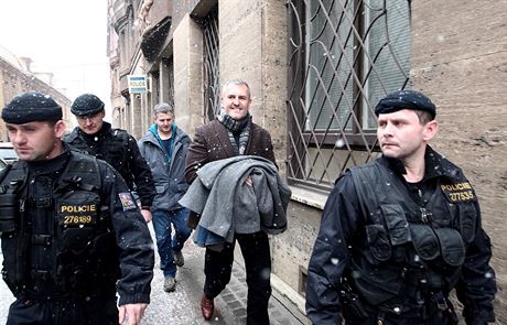 Policisté odvádjí Petra Sisáka  z budovy policie na praském Pertýn.