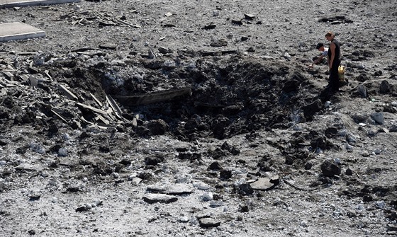 Obyvatelé msta Makijivka leící východn od Doncku si prohlíejí kráter po...