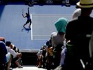 Zajímavý pohled z tribuny na podávajícího kanadského tenistu Milose Raonice.