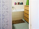 Koupelna s mozaikovou podlahou a obkladem z bílých tvercových kachlík od...