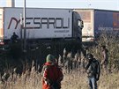 Obyvatelé uprchlického tábora v Calais se snaí dostat do kamion míících do...