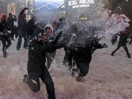 Desítky lidí se sely na zasneném Times Square, aby se zapojily do hromadné...