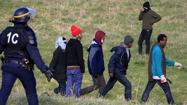 Francouzsk policista se sna zastavit migranty na severu Francie snac se dostat do Britnie. (21. 1. 2016)