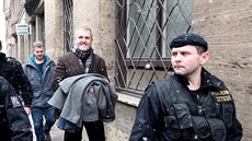 Policisté odvádějí Petra Sisáka  z budovy policie na pražském Perštýně.