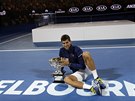 SÁM SE SVOU TROFEJÍ. Novak Djokovi si uívá triumf na Australian Open.