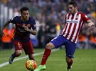 Barcelonský obránce Dani Alves (vlevo) a Koke z Atlétika Madrid.