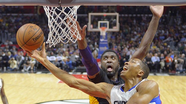 Wesley Johnson (v blm) z Los Angeles Clippers zakonuje kolem Roye Hibberta z Los Angeles Lakers.